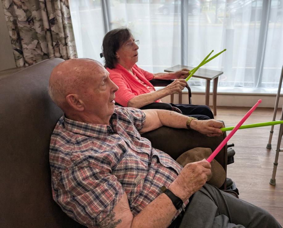 older adults with colourful drum sticks