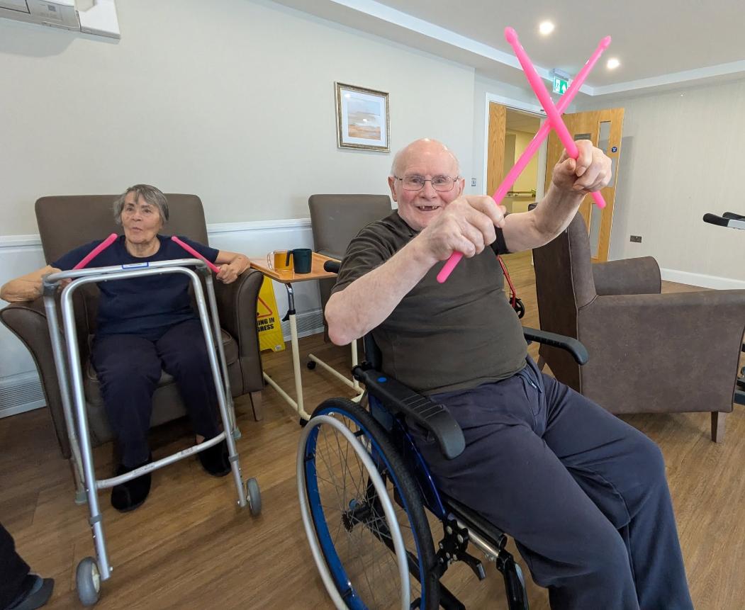 older adults with colourful drum sticks