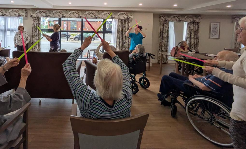 older adults with colourful drum sticks