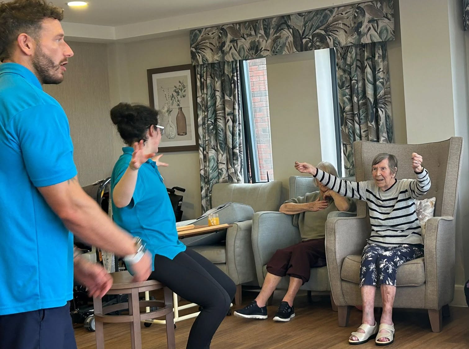 staff sitting with residents stretching